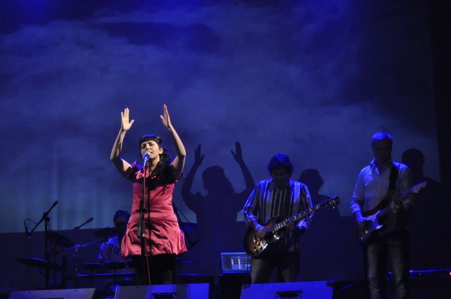 Sol Aravena on stage with her band under blue light