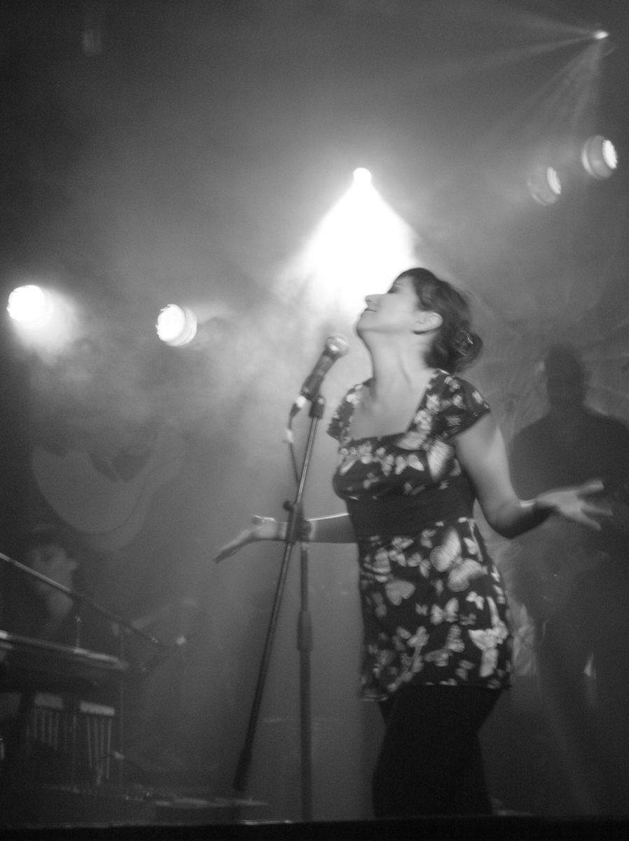 Sol Aravena singing, black-and-white concert photo